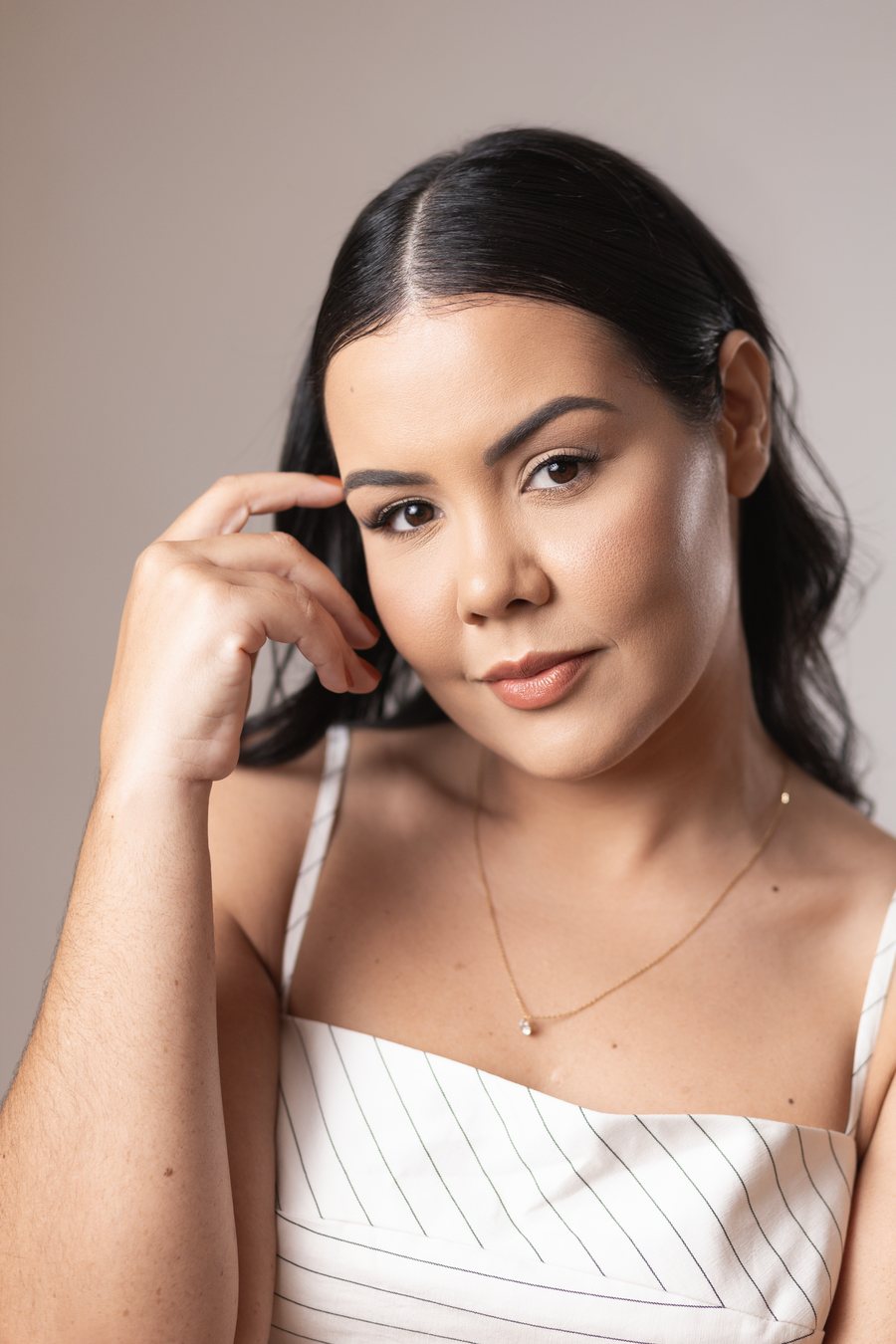 Jennedy Lima em retrato aproximado, a mão junto à sobrancelha, olhando para a câmera.